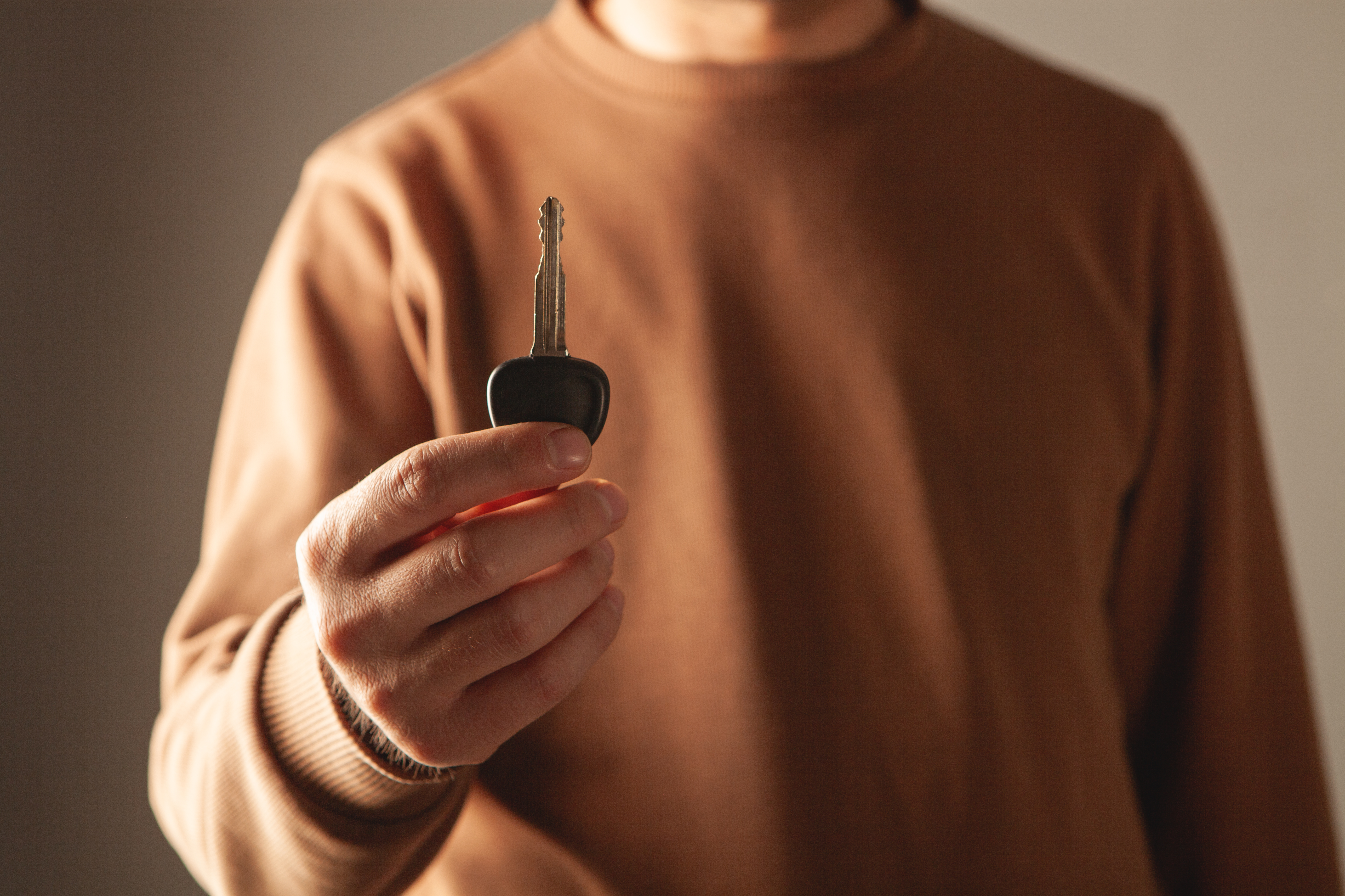 Close-up of a man's hand holding a car key.